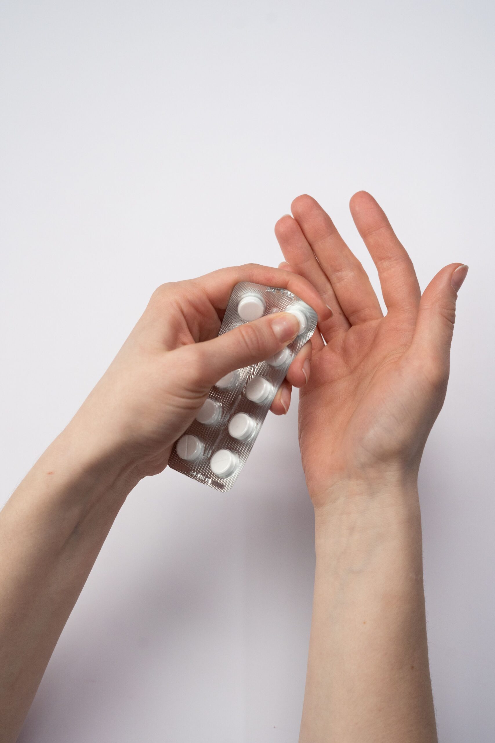 Woman opening a package of white pills